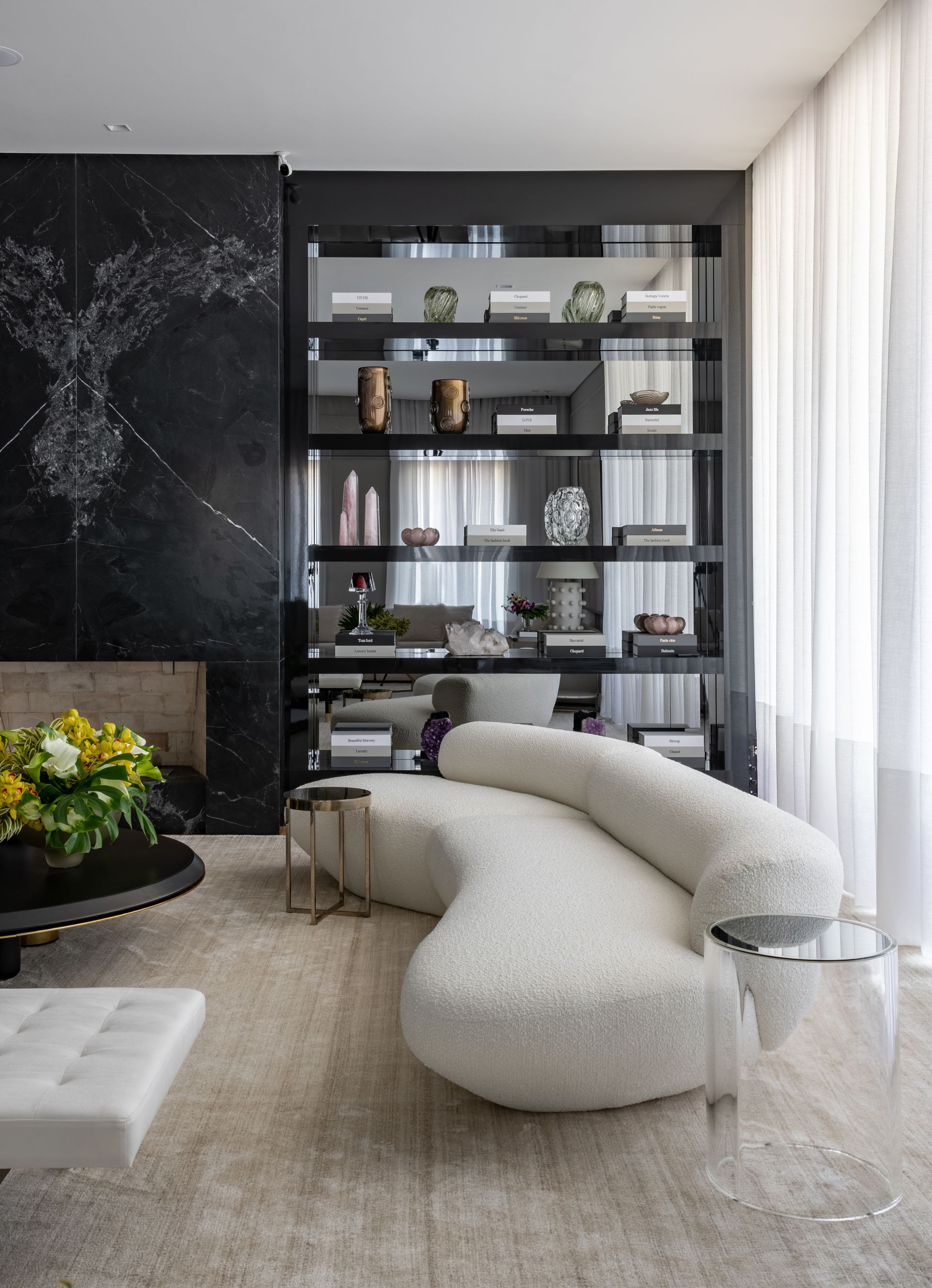 Uma sala de estar com um sofá branco e uma parede preta