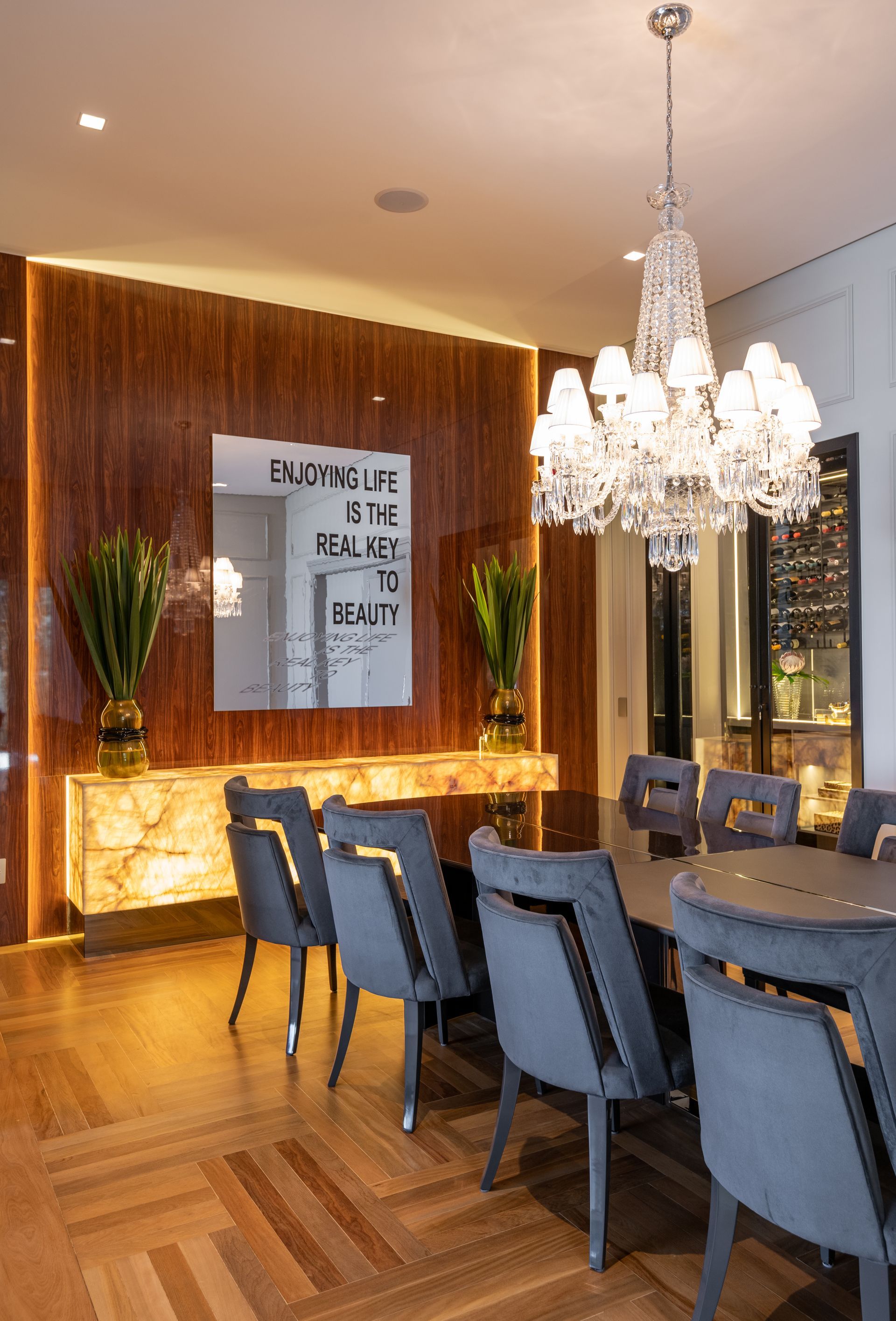 Uma sala de jantar com uma mesa e cadeiras e um lustre pendurado no teto.