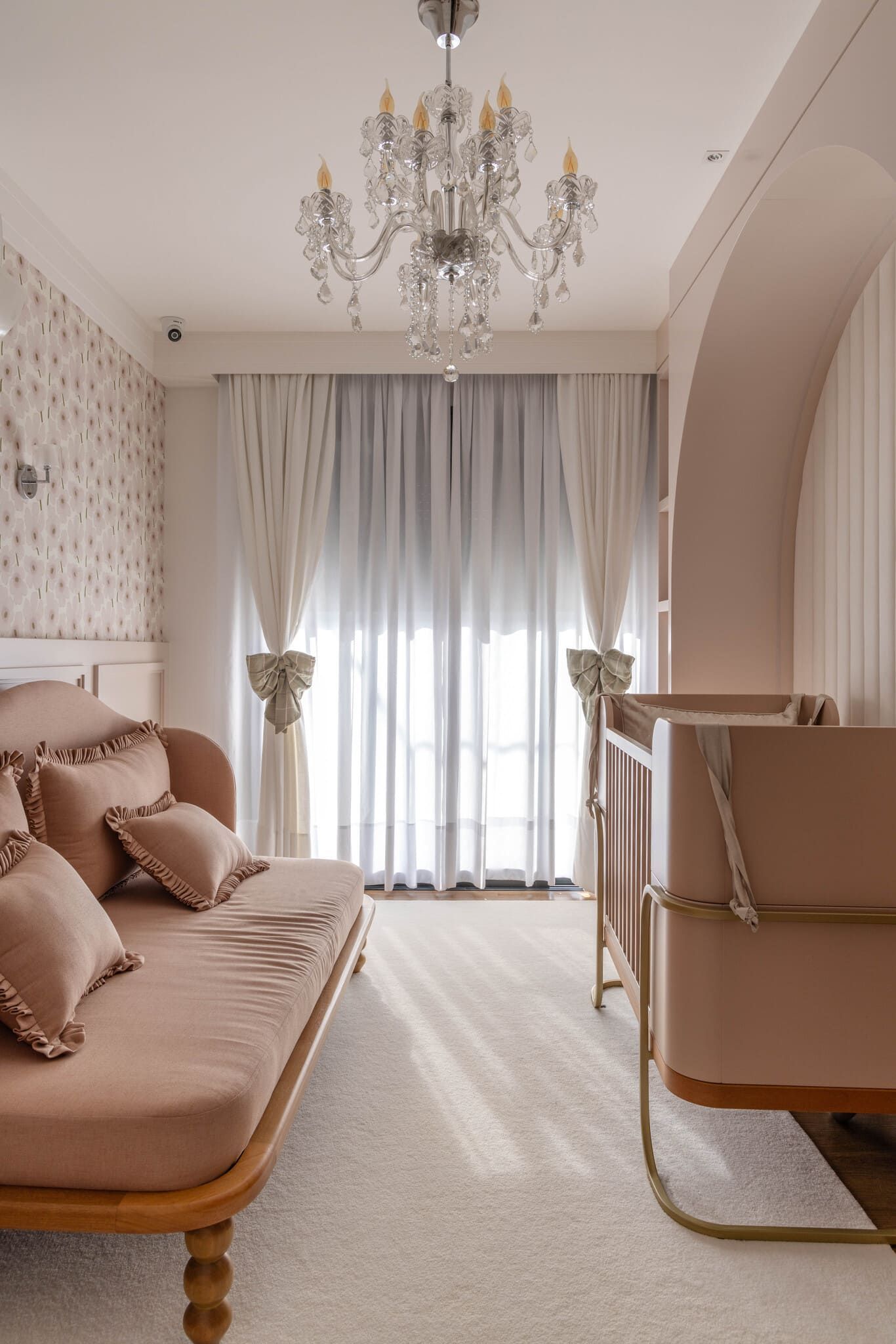 Há um sofá e um berço no quarto.