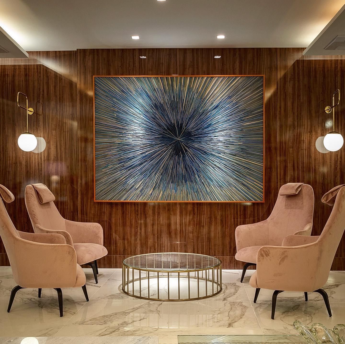 Há uma grande pintura na parede acima das cadeiras.