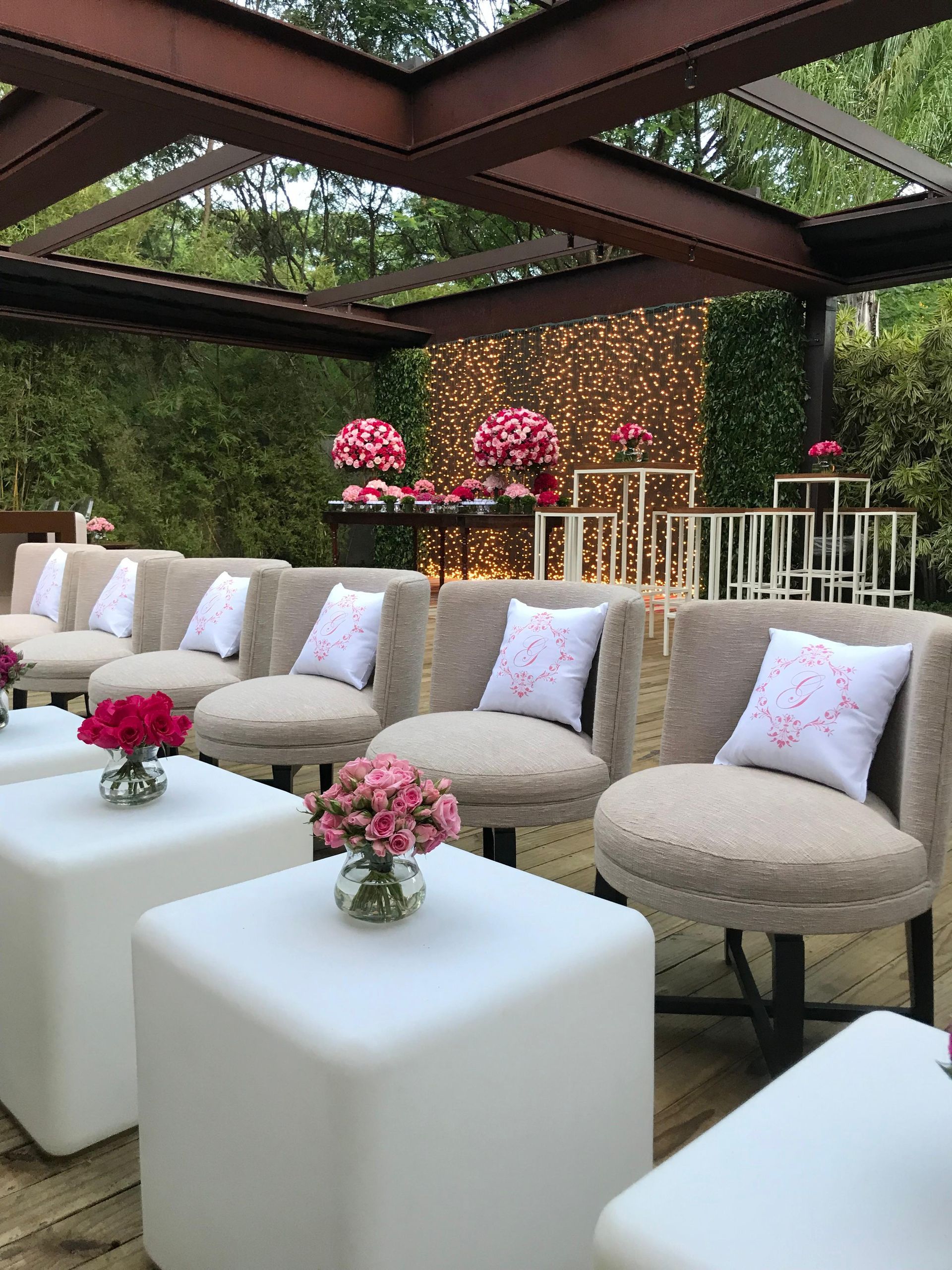 Uma fileira de cadeiras e mesas com vasos de flores sobre elas.