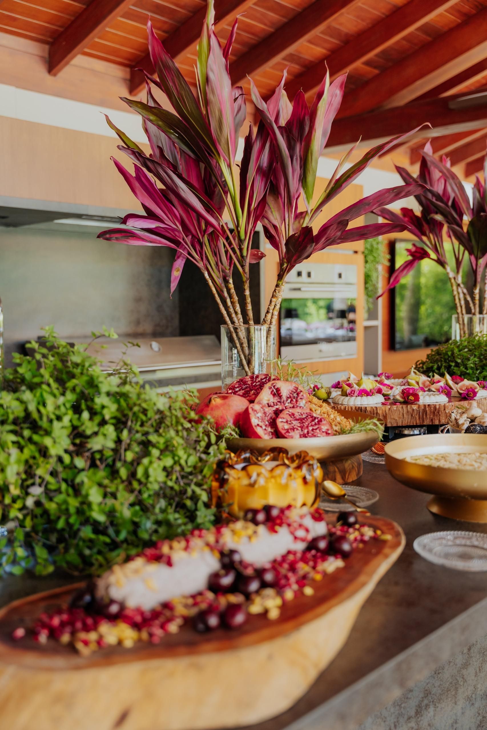 Uma tigela de madeira cheia de comida e flores sobre uma mesa.