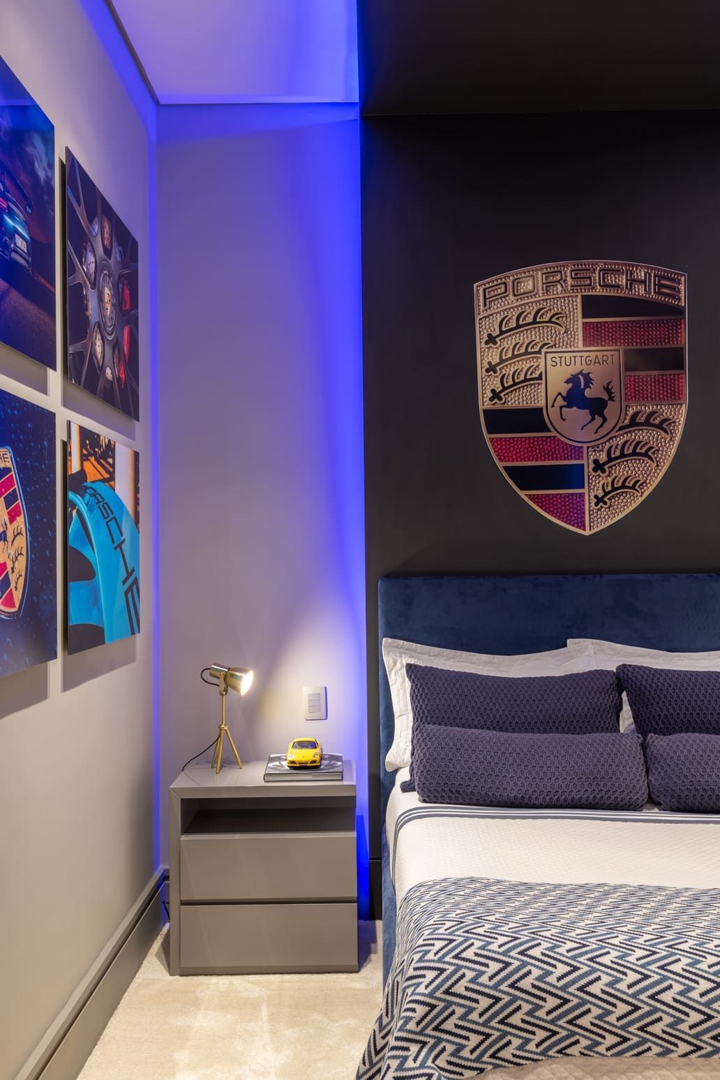 Um quarto com uma cama, mesa de cabeceira e um escudo na parede.