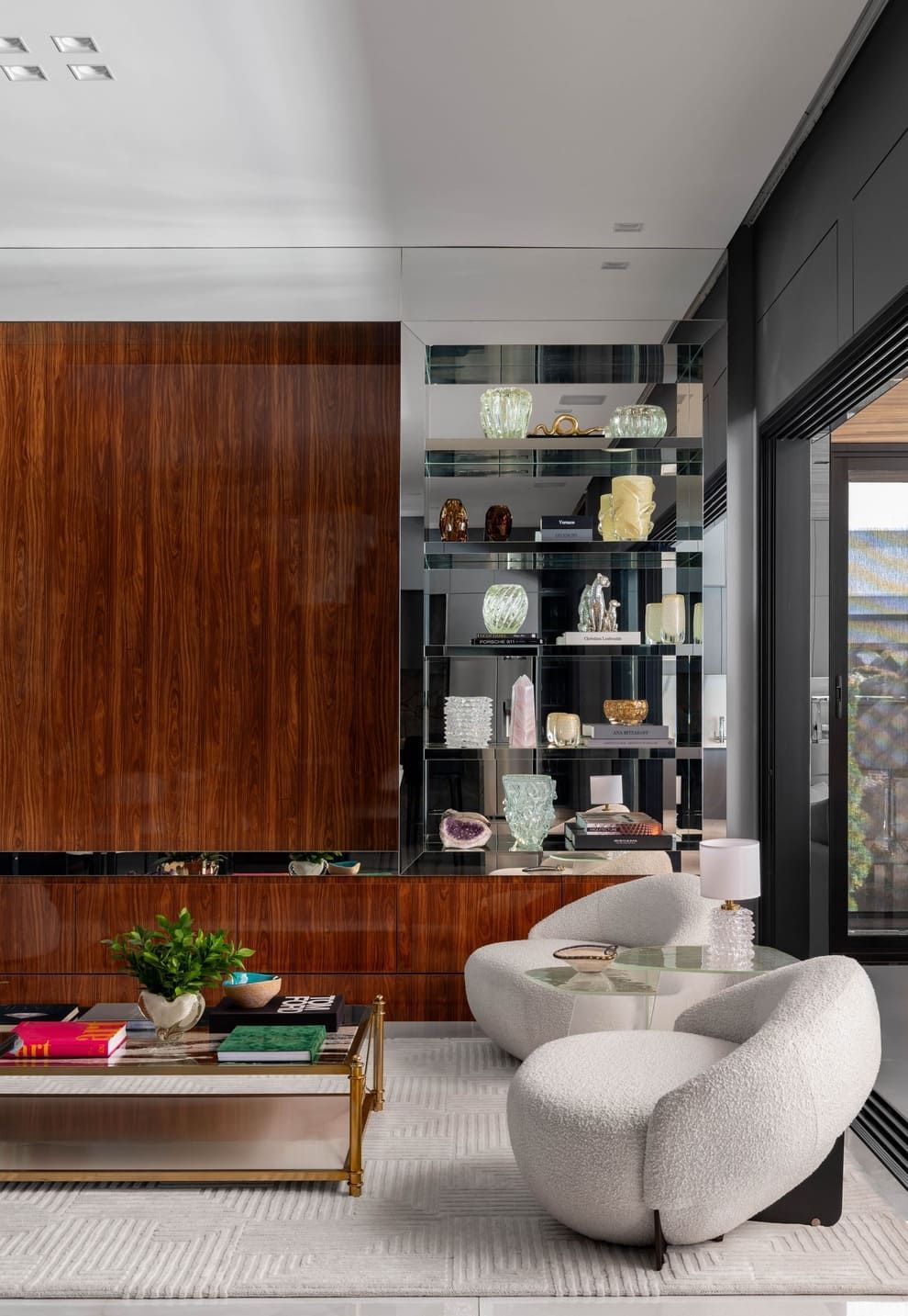 Uma sala de estar com duas cadeiras, uma mesa de centro e uma parede de madeira.