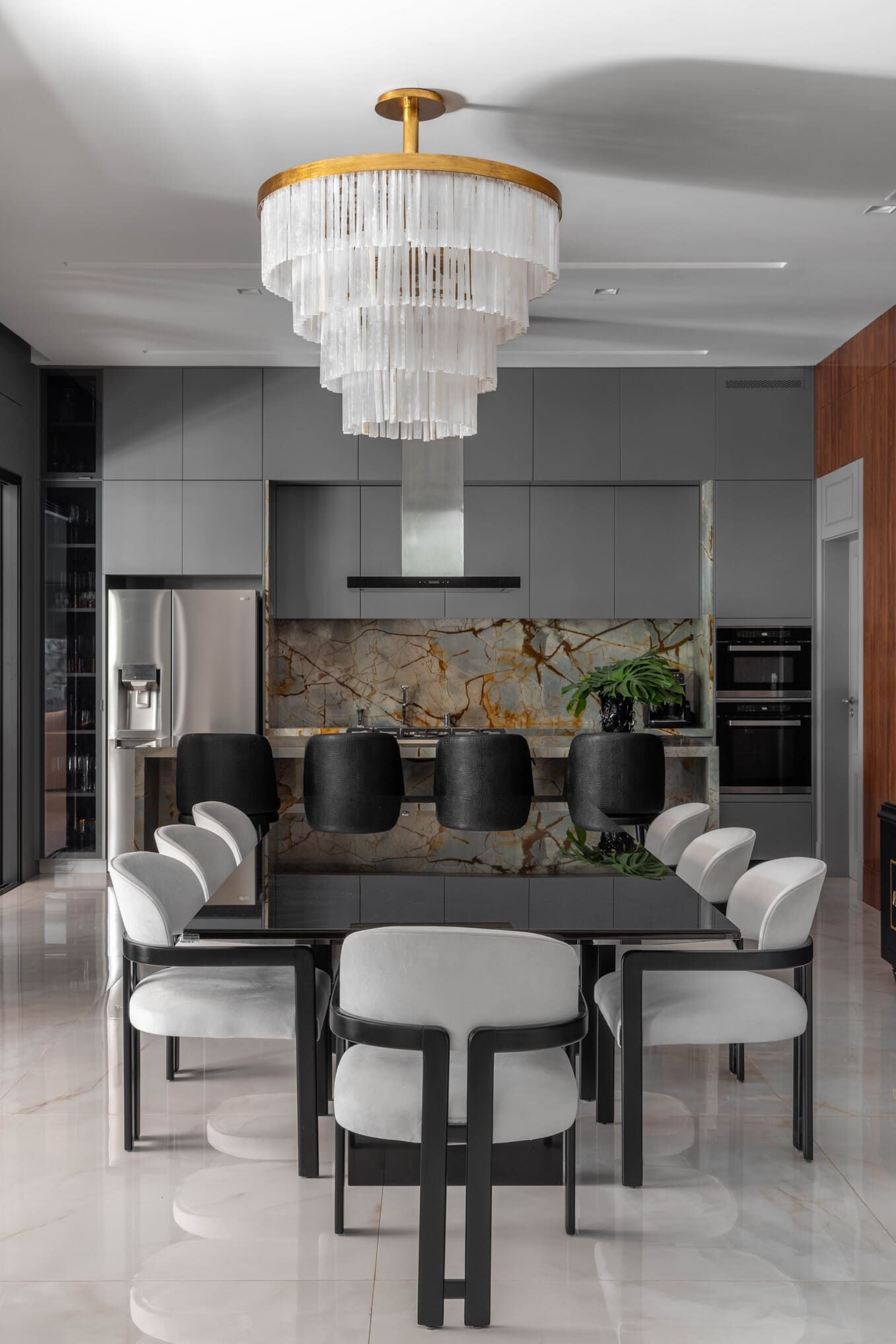 Uma sala de jantar com uma mesa e cadeiras e um lustre pendurado no teto.