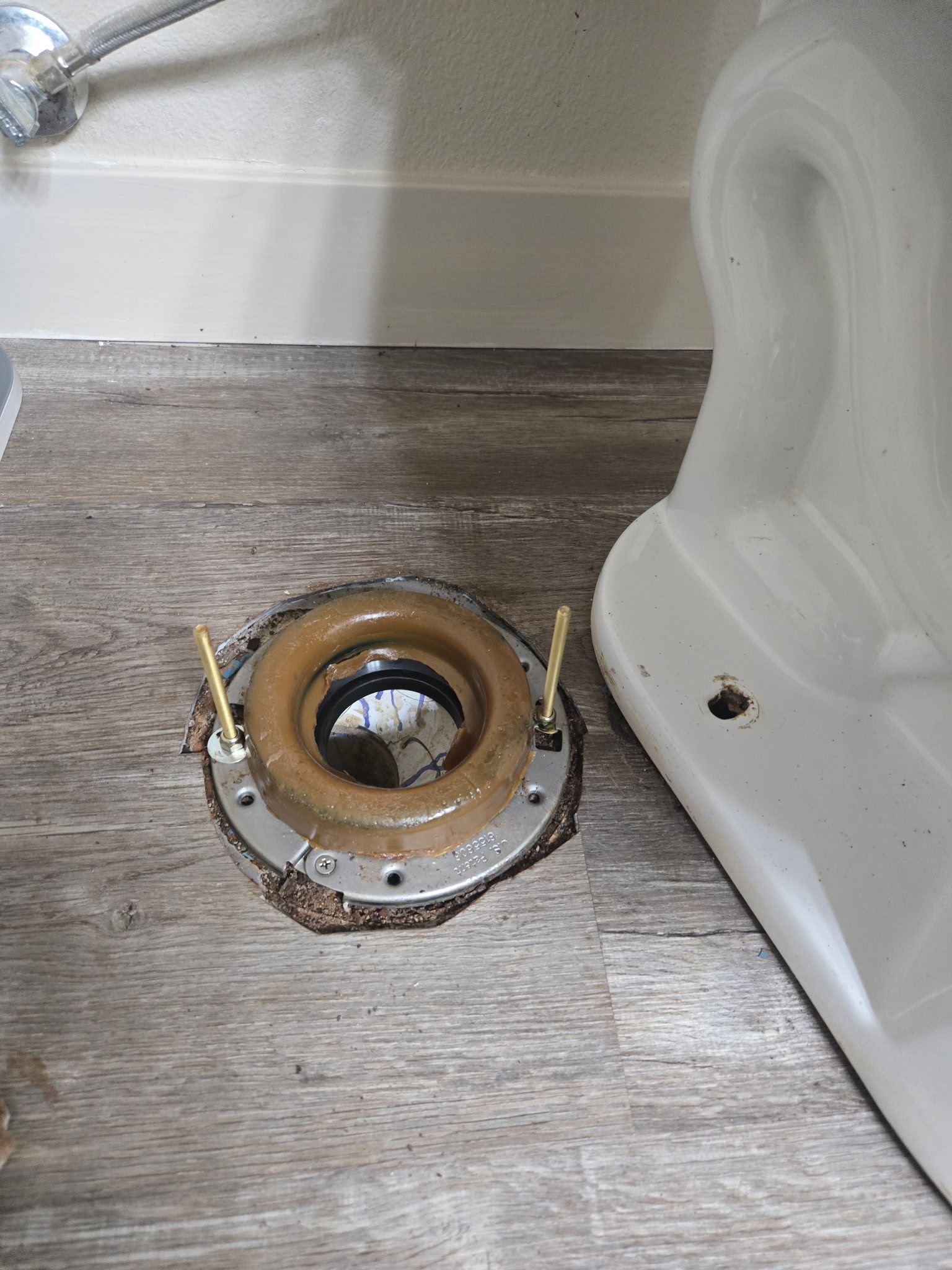 Person assembling plumbing pipes in a trench, using a rag and O-rings outdoors.