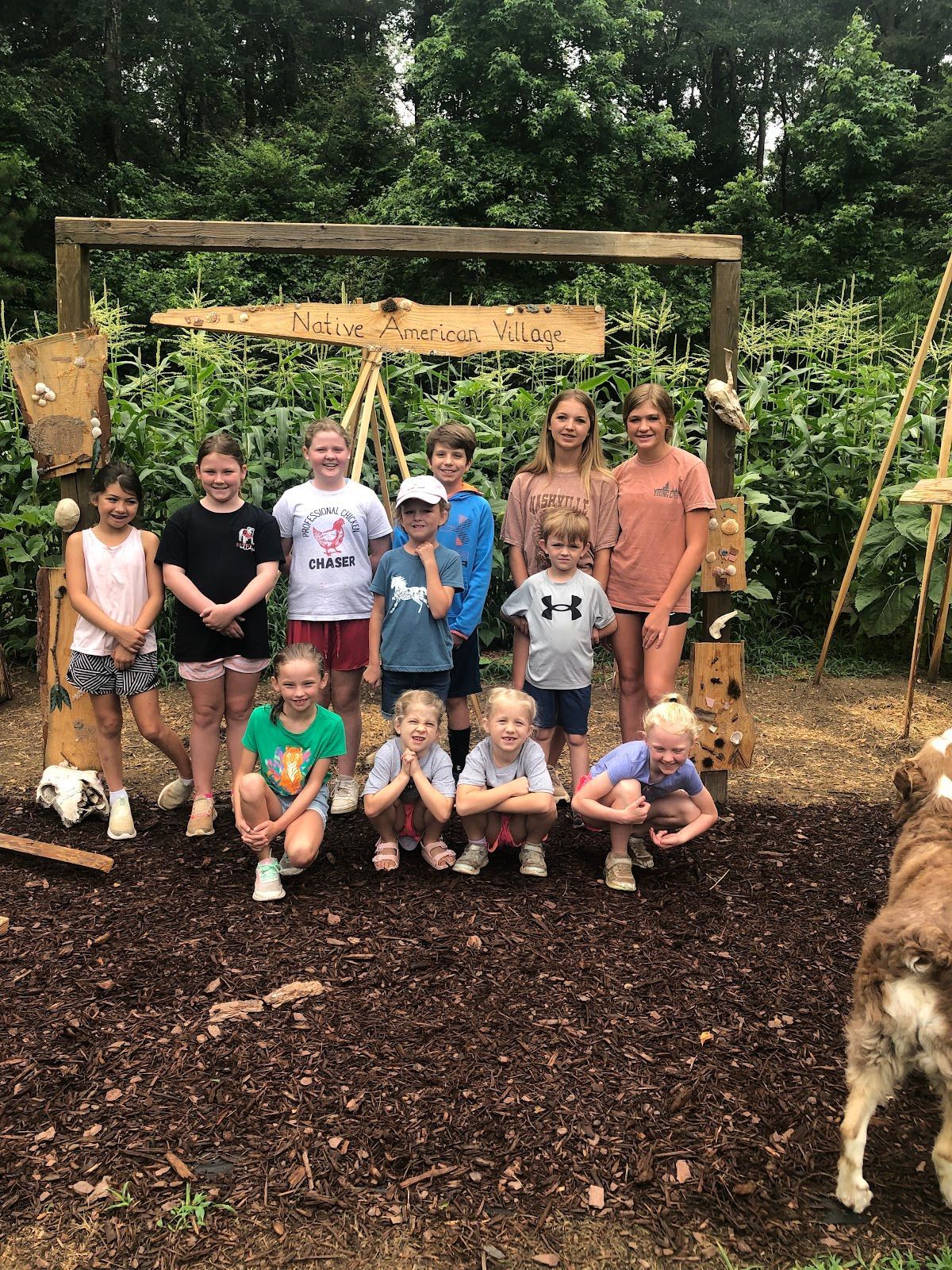 A group of children are posing for a picture with a dog.