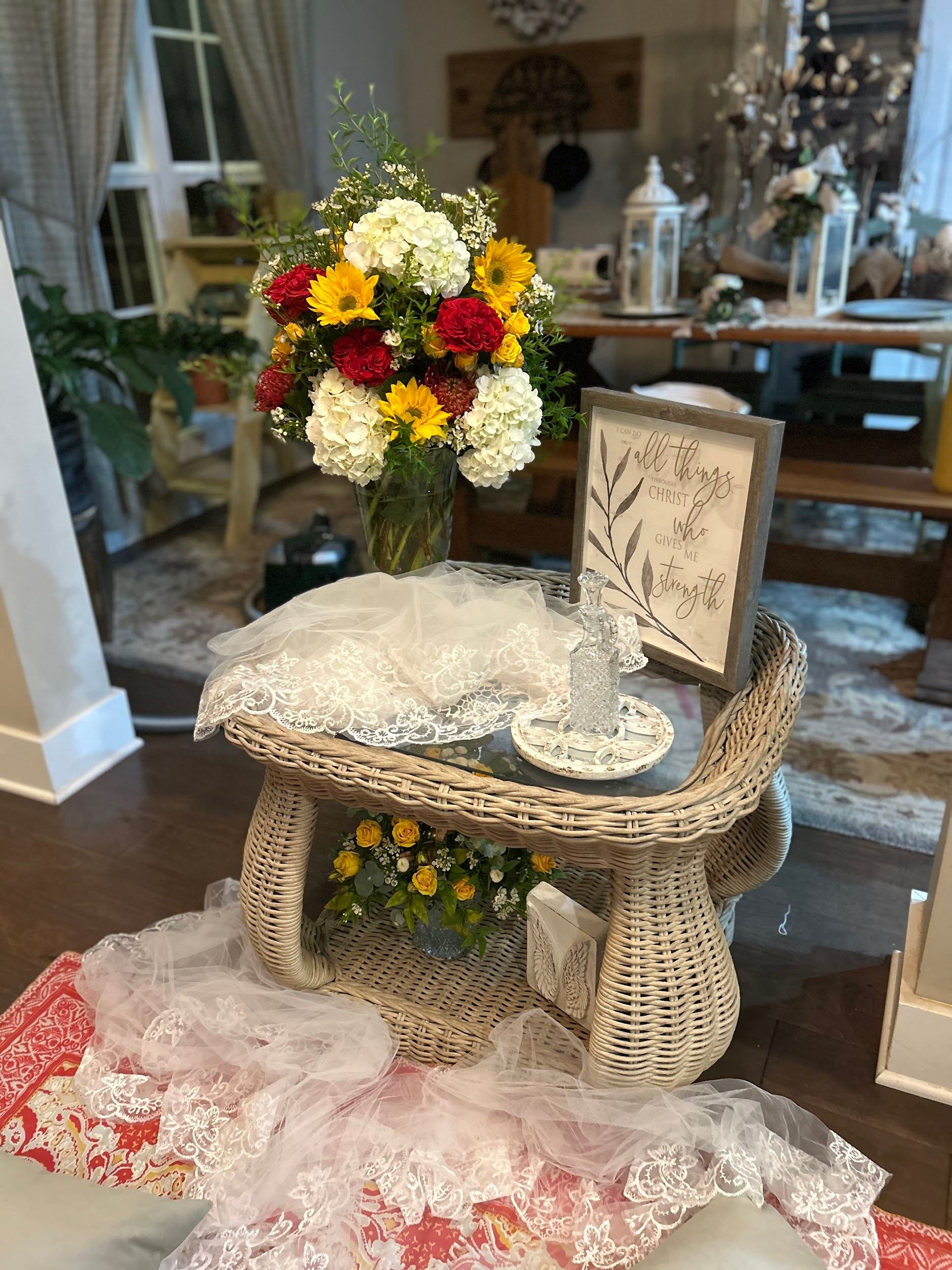 A wicker table with a vase of flowers on it in a living room.