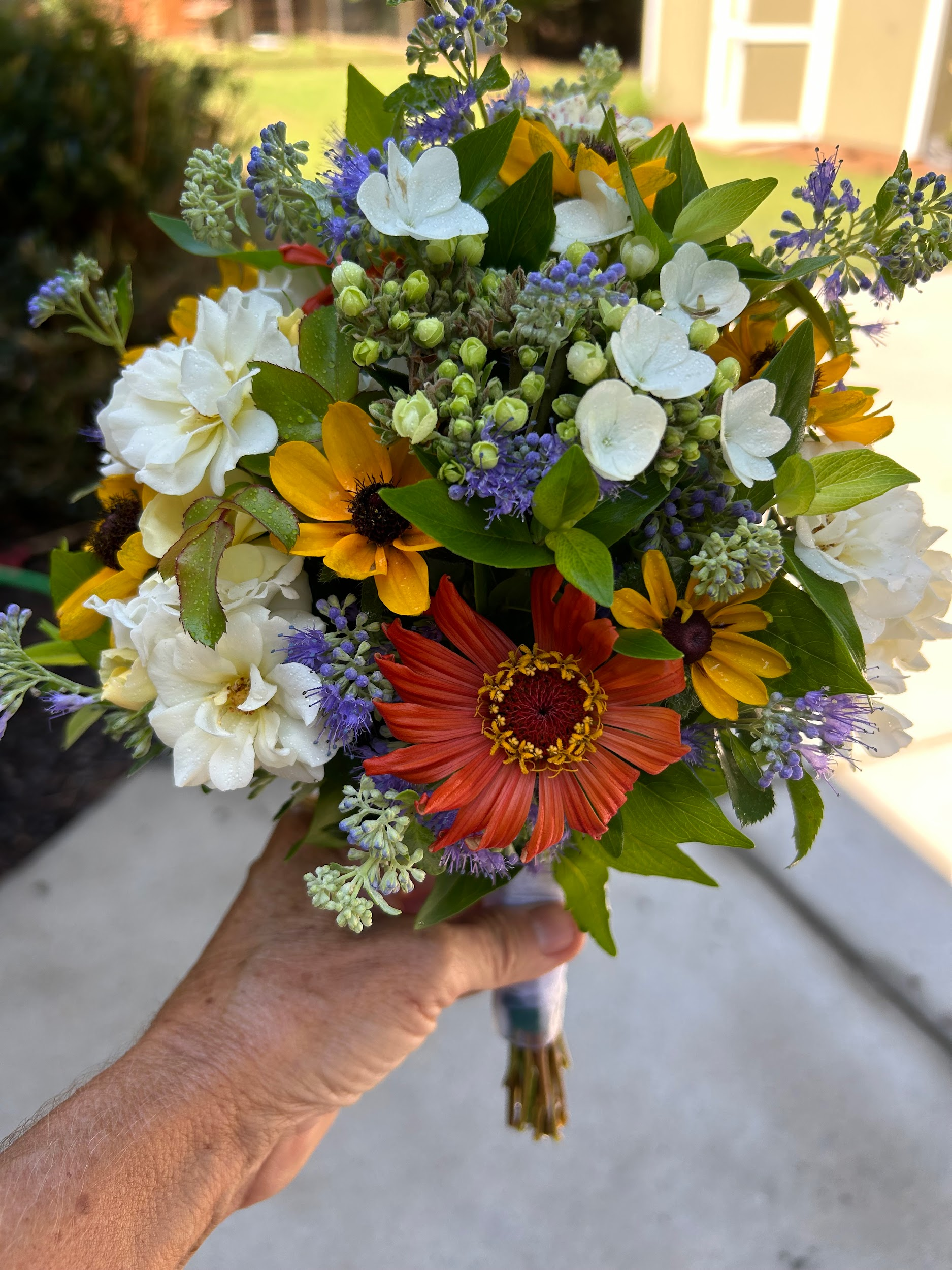 A person is holding a bouquet of flowers in their hand.