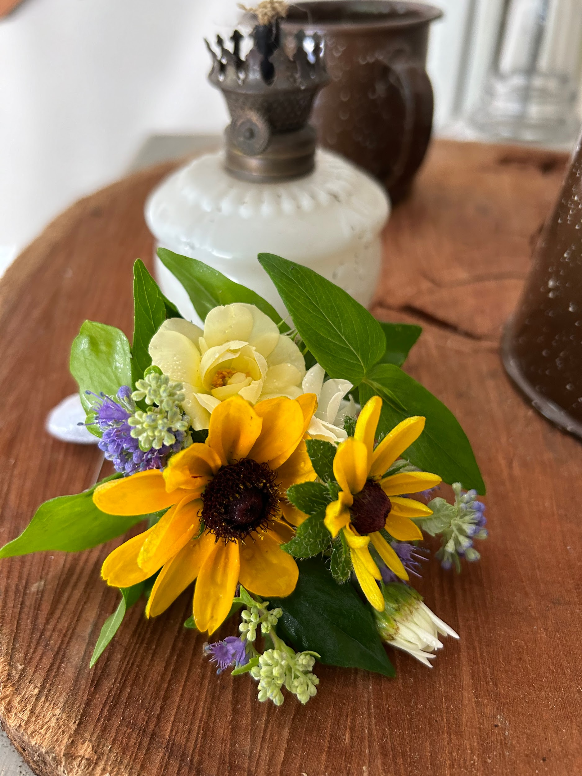 A bunch of yellow flowers are sitting on a wooden table.