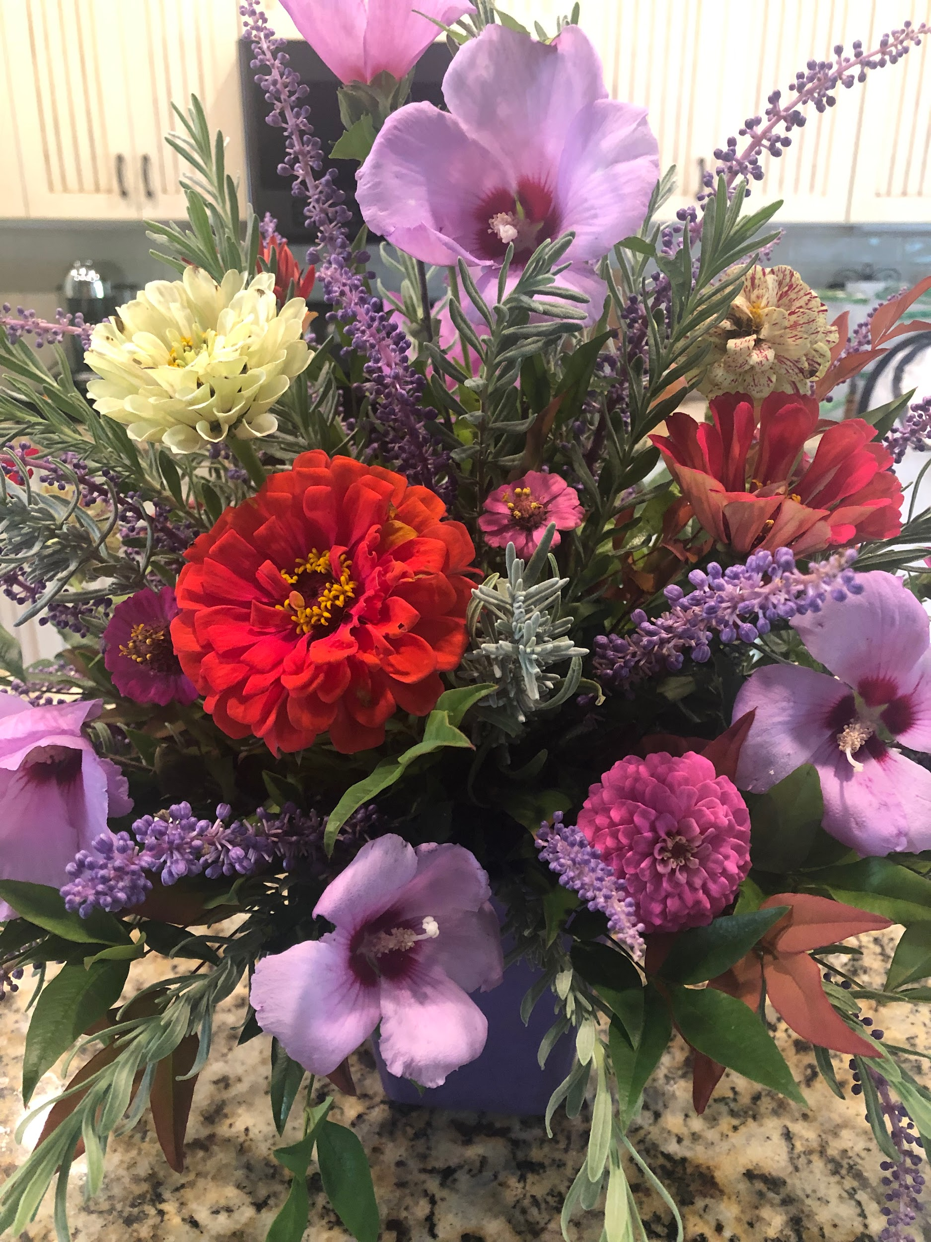 A bouquet of flowers is sitting on a counter.