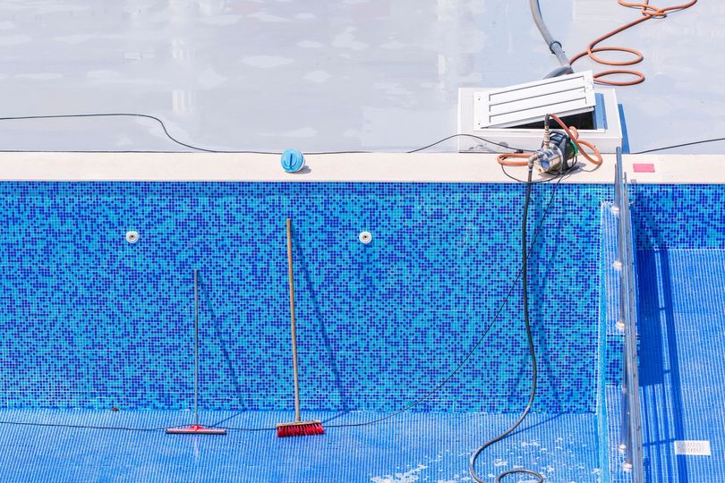 A swimming pool is being built and being filled with water.