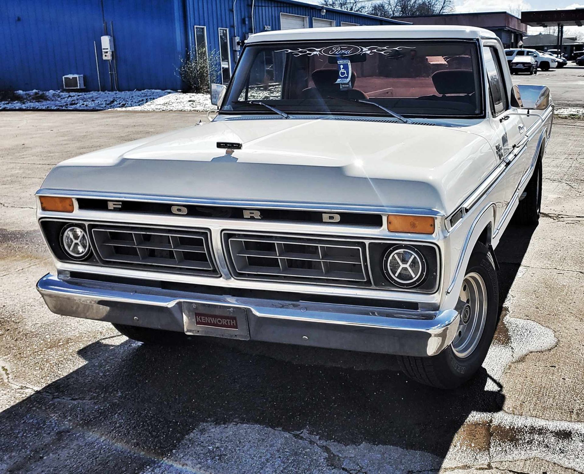 A white ford truck is parked in a parking lot