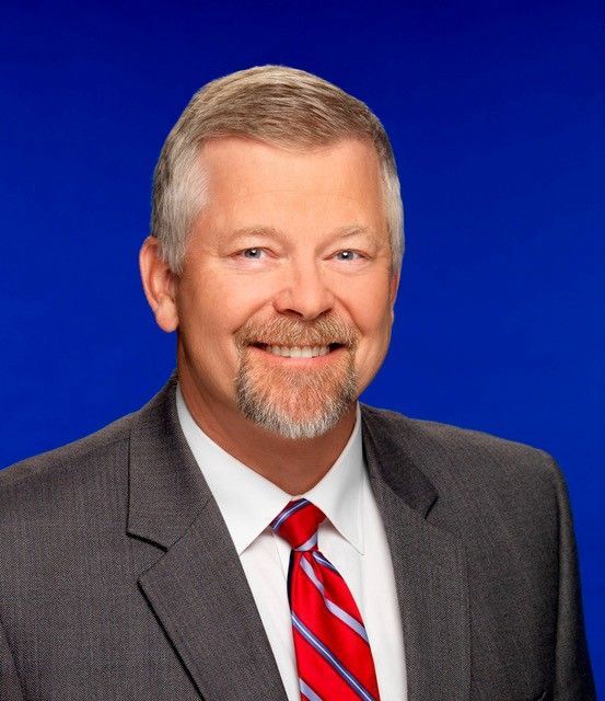 A man and a woman are posing for a picture and smiling
