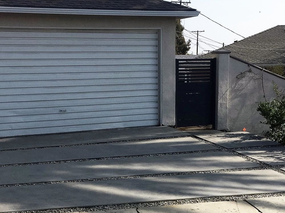 A white garage door with a black gate in front of it