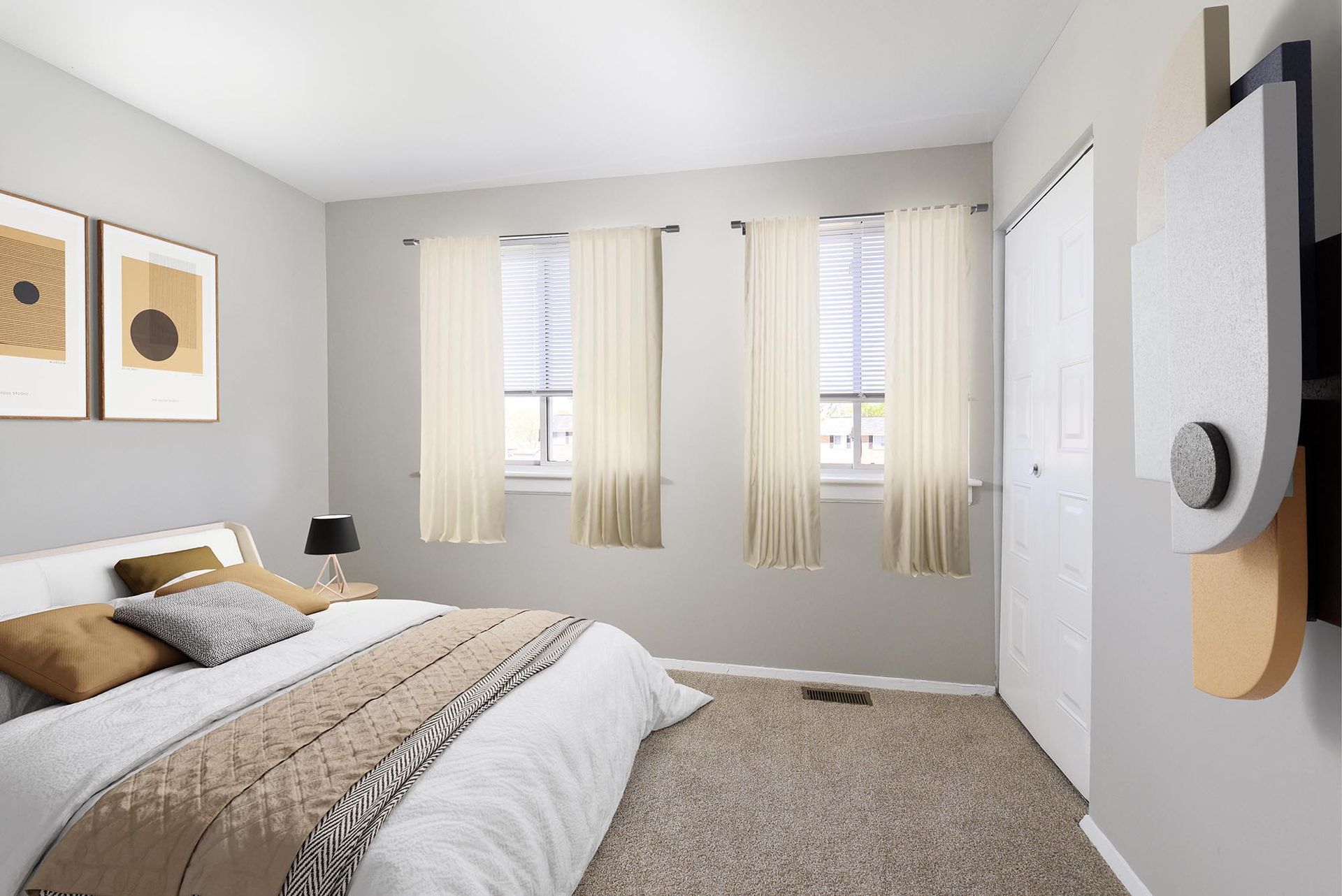 Bedroom with a bed, two windows with curtains, art on the wall, and a closed door.