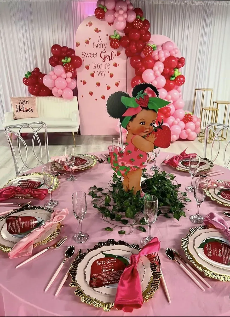 Pink Minnie Mouse-themed birthday table with balloons, plates, and a centerpiece