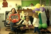 A woman and two children are playing with balloons in a living room.