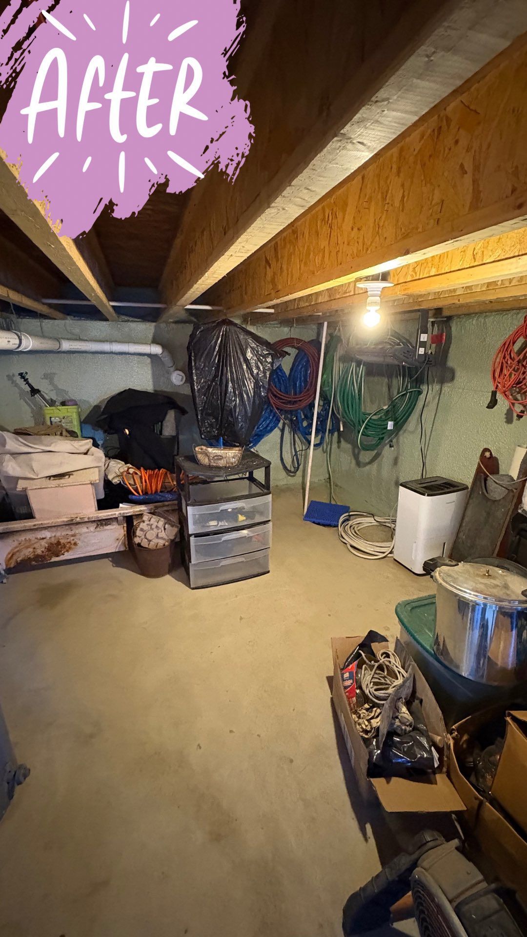 Basement storage area after organization, with concrete floor, exposed beams, and assorted items.