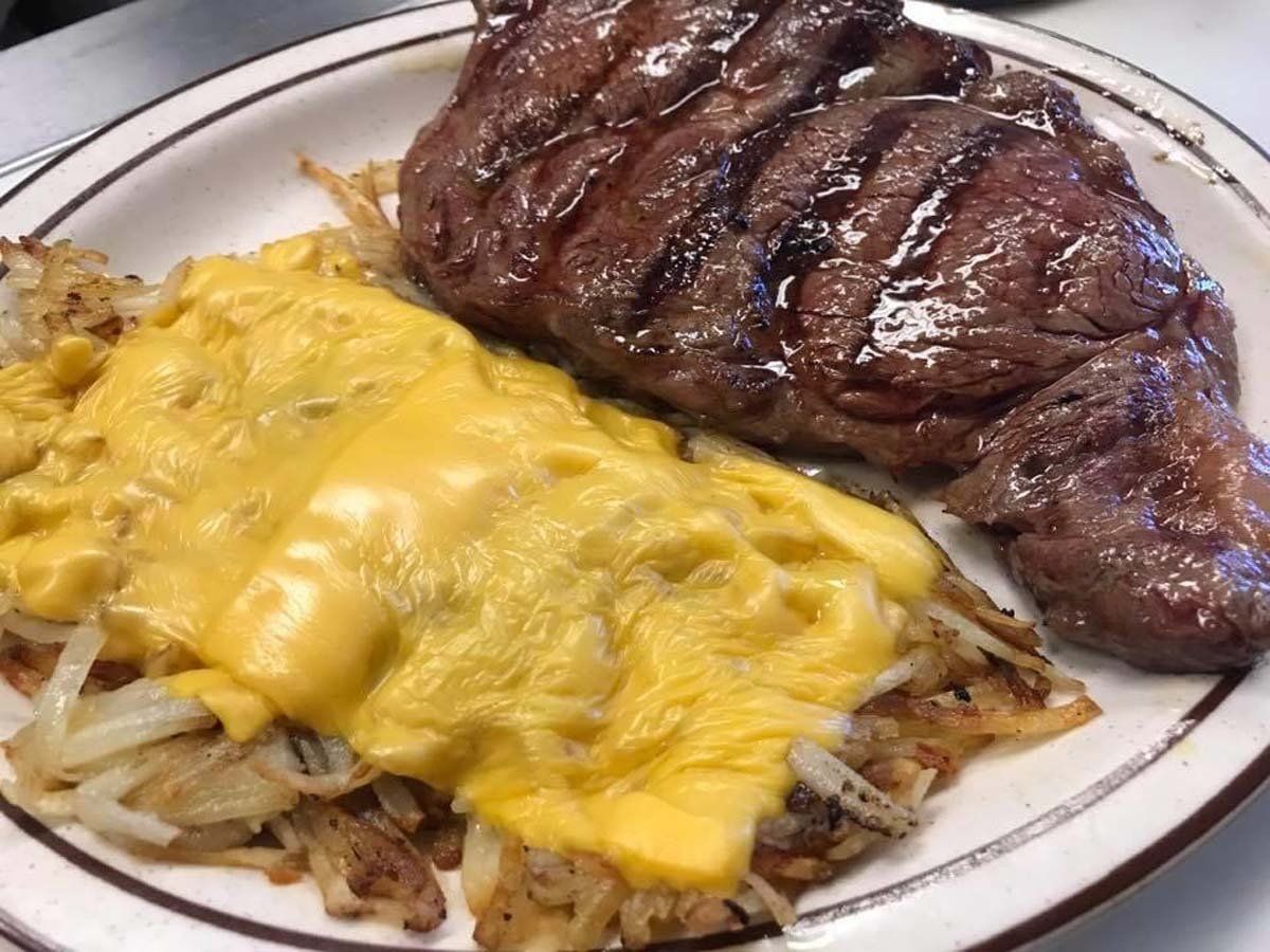A plate of food with a steak and cheese on it.