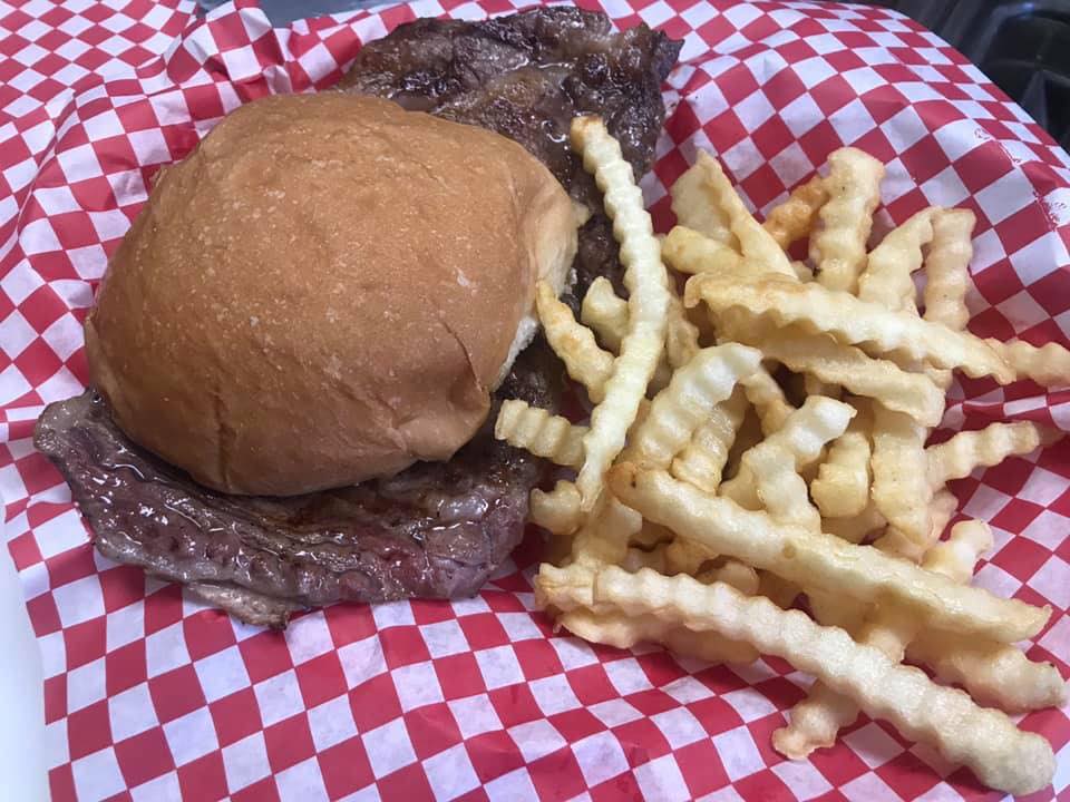 A hamburger and french fries on a checkered cloth