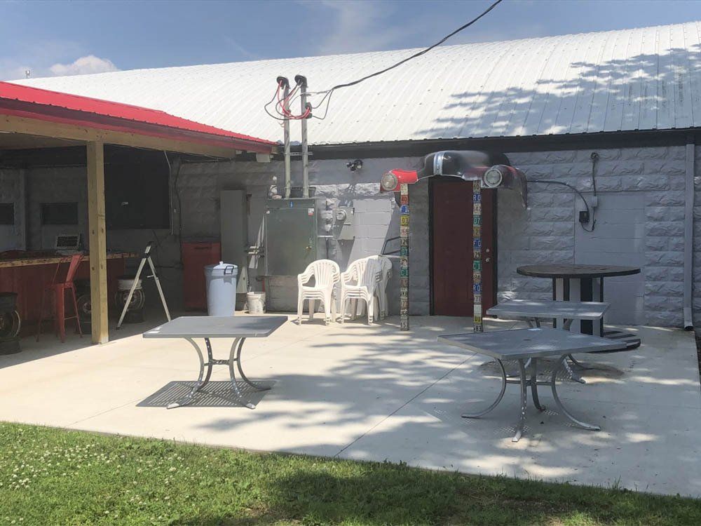 A patio with tables and chairs in front of a building.
