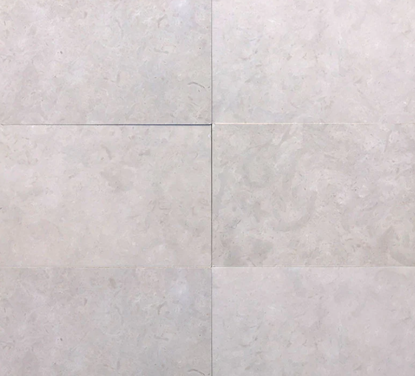 A close up of a white limestone tile floor.