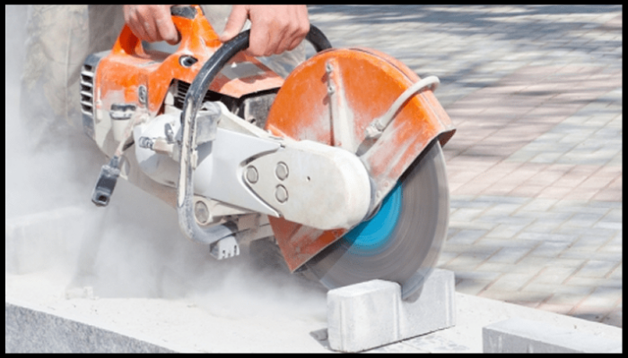 A person is cutting concrete with a circular saw.