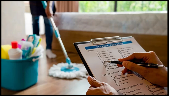 Close-up of cleaning service checklist with a professional cleaner working in the background.