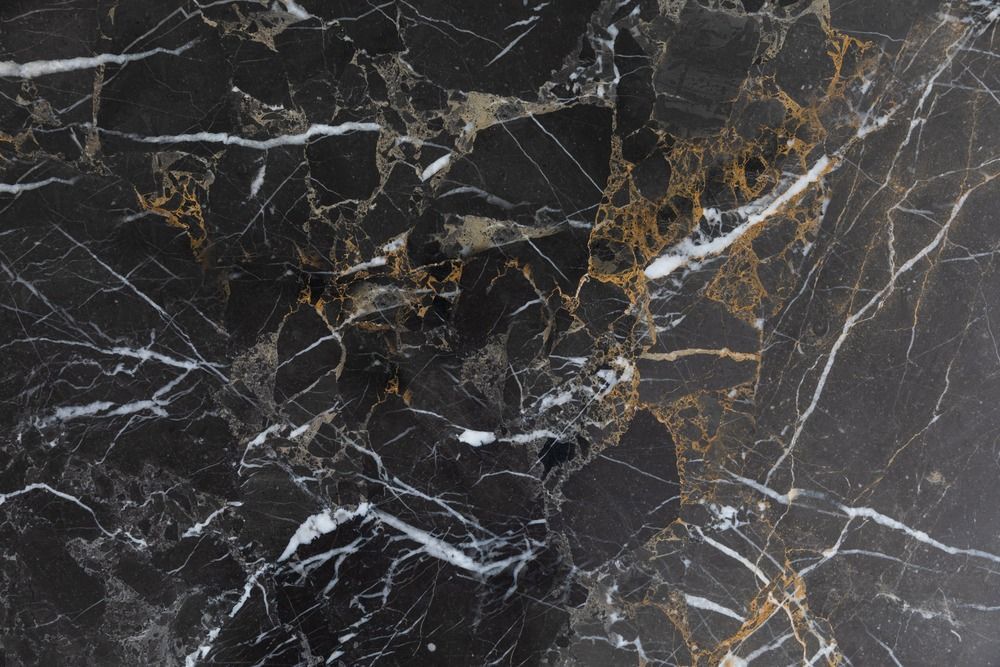 A close up of a black and gold marble counter top.