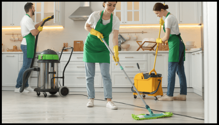 Team of professional end of lease cleaners with industrial equipment cleaning a kitchen in Canberra.