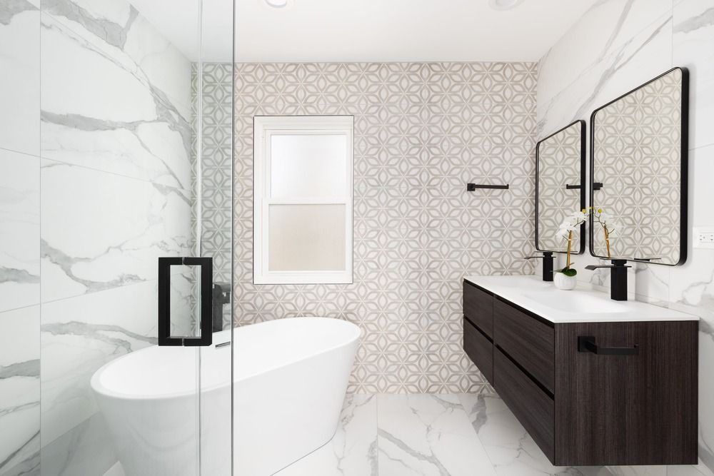 A bathroom with a tub , sink , mirrors and a walk in shower.