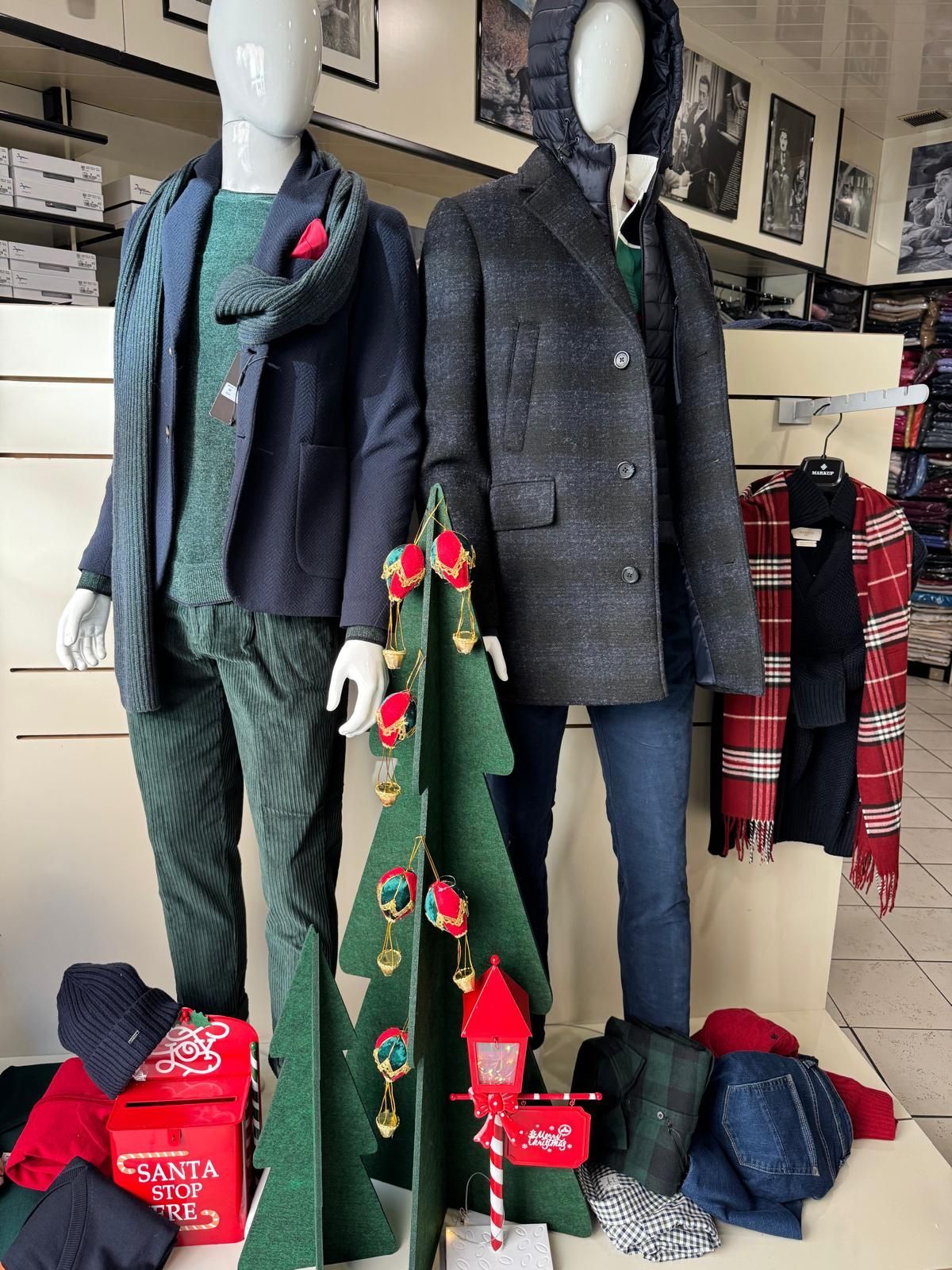 Vetrina con manichini in abiti invernali. Allestimento di un albero di Natale e accessori invernali in stile negozio.