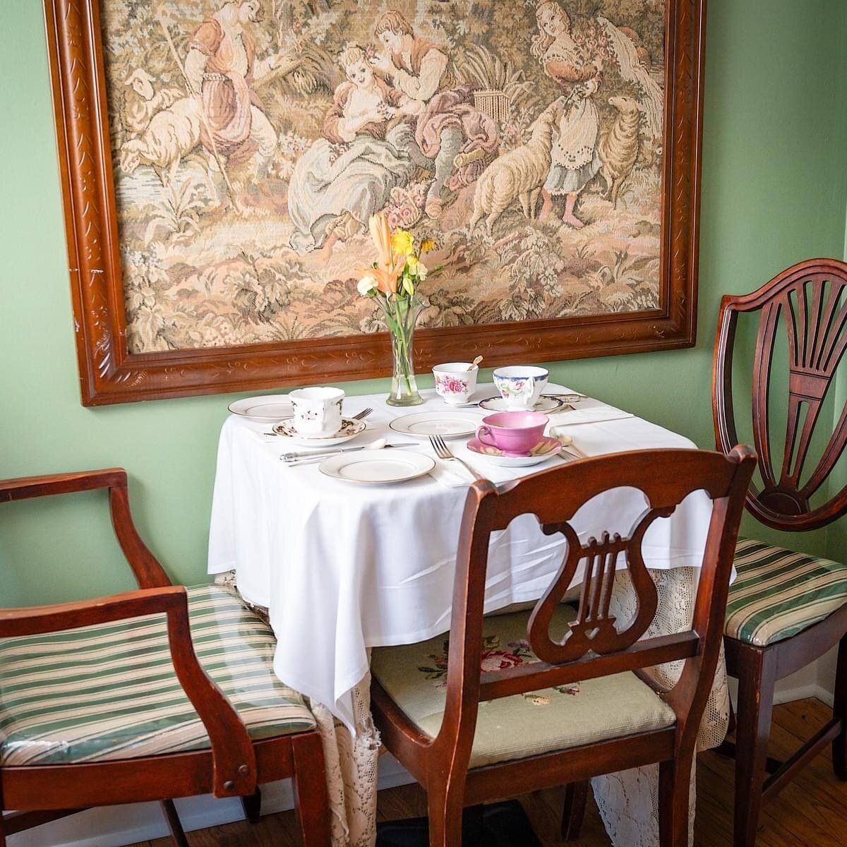 A table and chairs in a room with a painting on the wall.