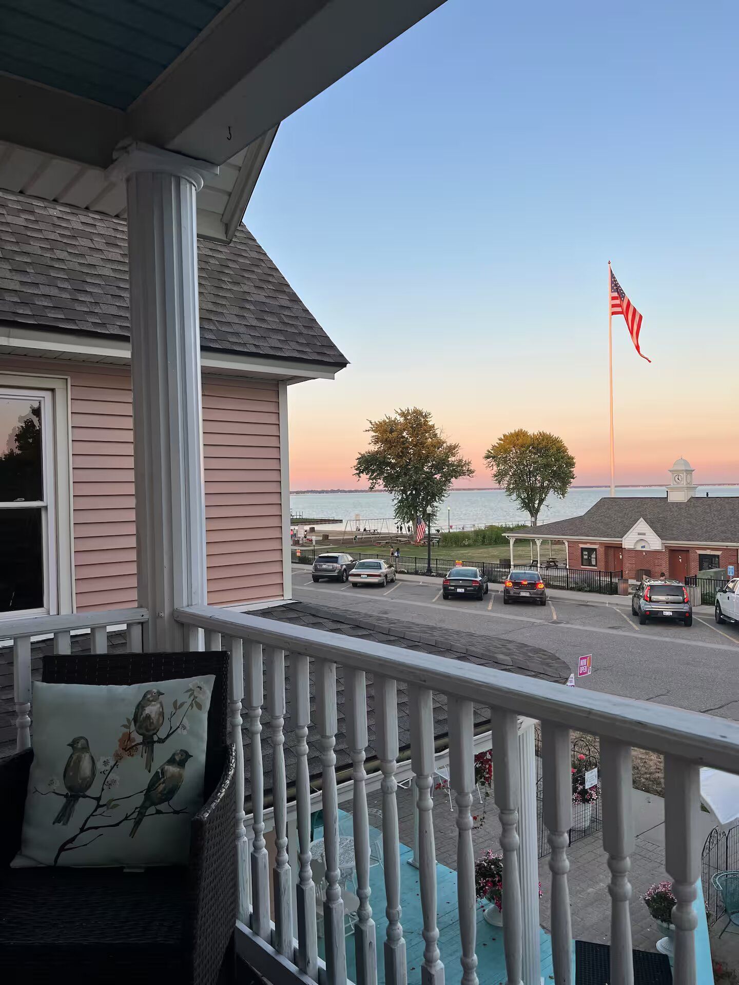 A balcony with a view of a street and a flag.