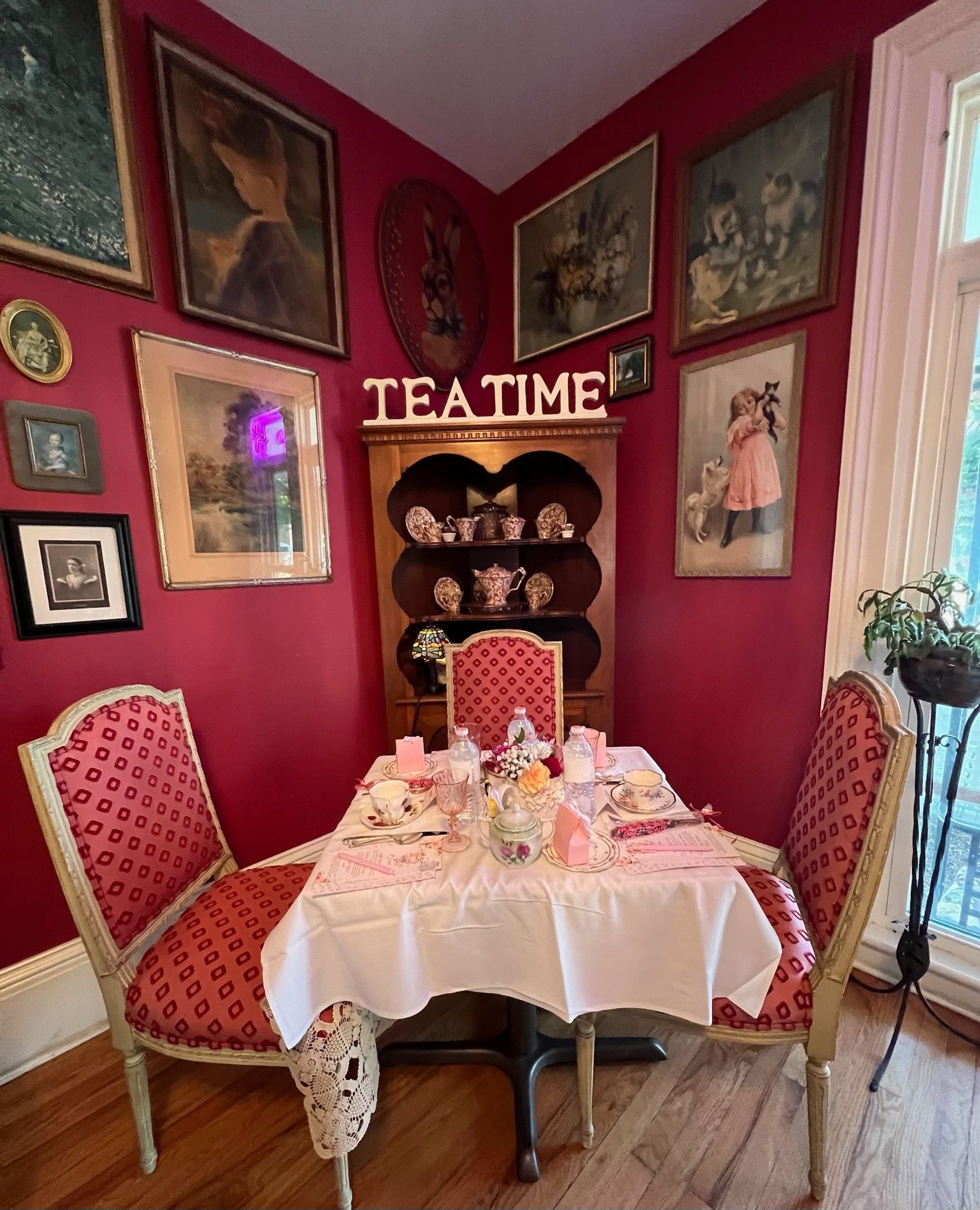 A room with a table and chairs and a sign that says teatime.