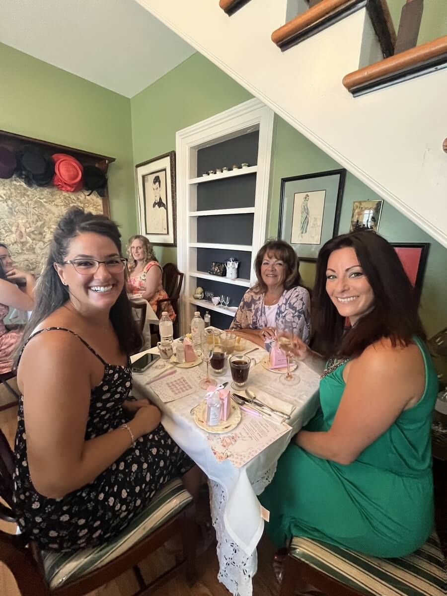 A group of women are sitting at a table in a room.