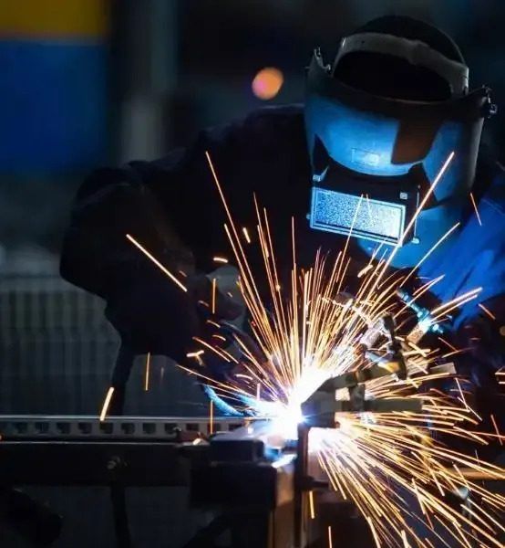 A Man Wearing a Welding Mask is Welding a Piece of Metal — Febos Welding and Engineering In Corrimal, NSW