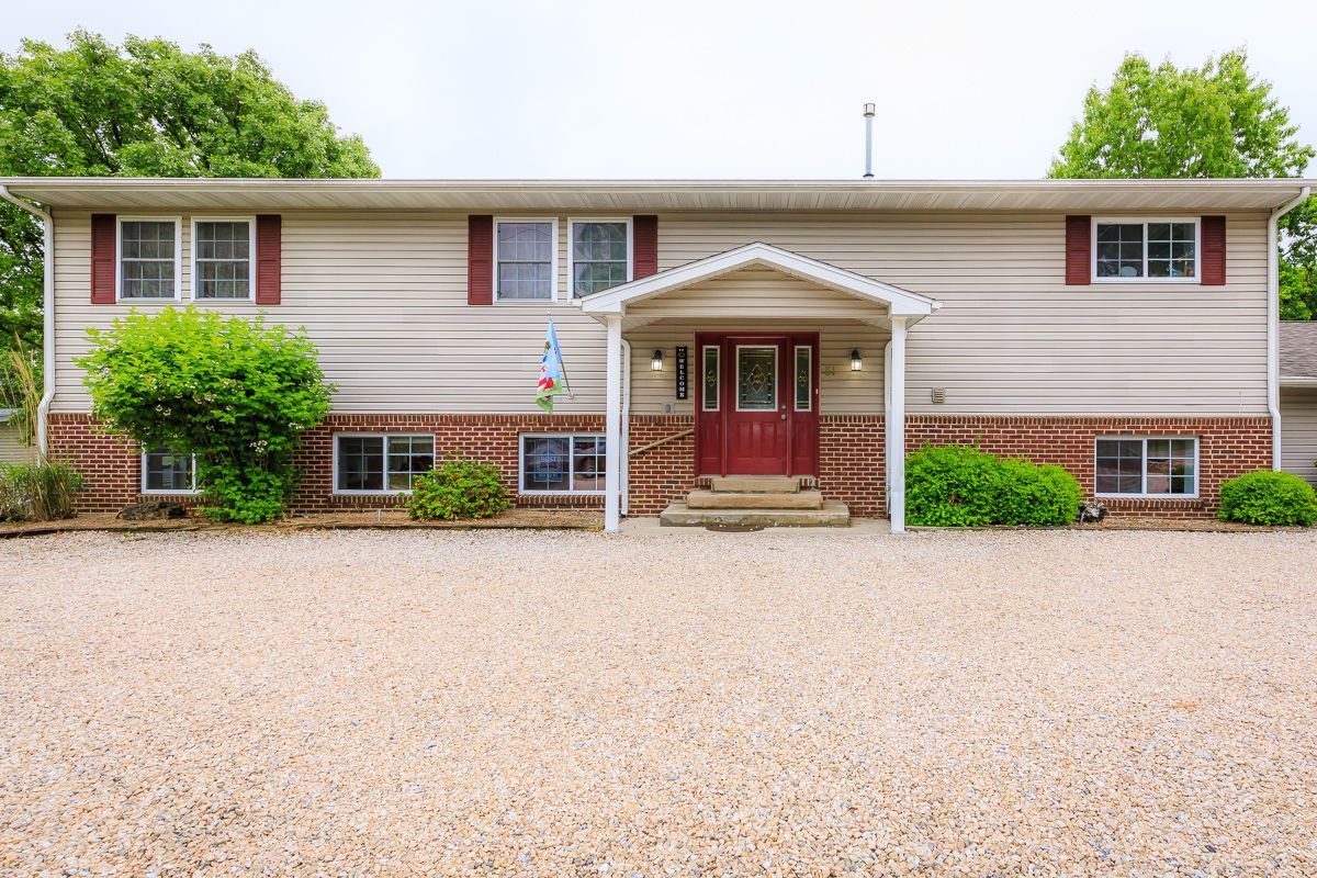A large house with a gravel driveway in front of it