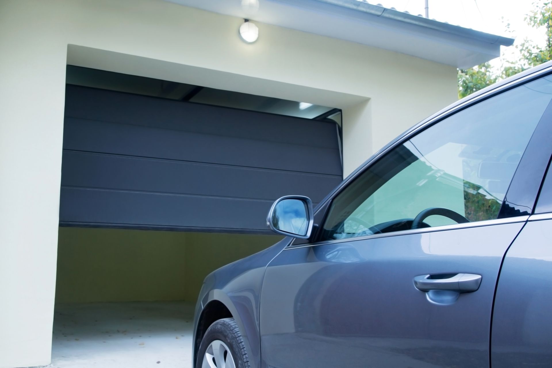 Car parked in front of an automatic garage door.