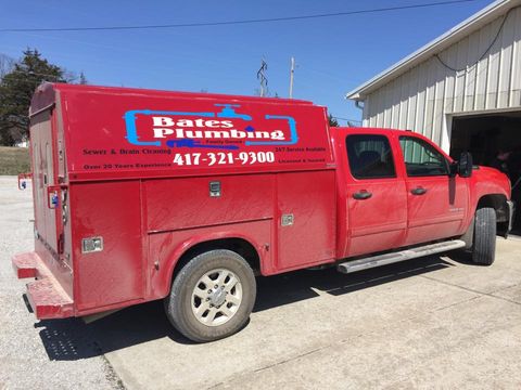 Nevada Missouri Plumber — Bates Plumbing Red Service Car in Schell City, MO