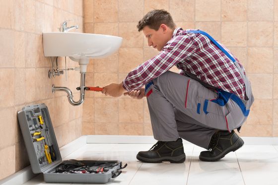 Schell City Plumber — Young Male Plumber Fitting Sink in Schell City, MO