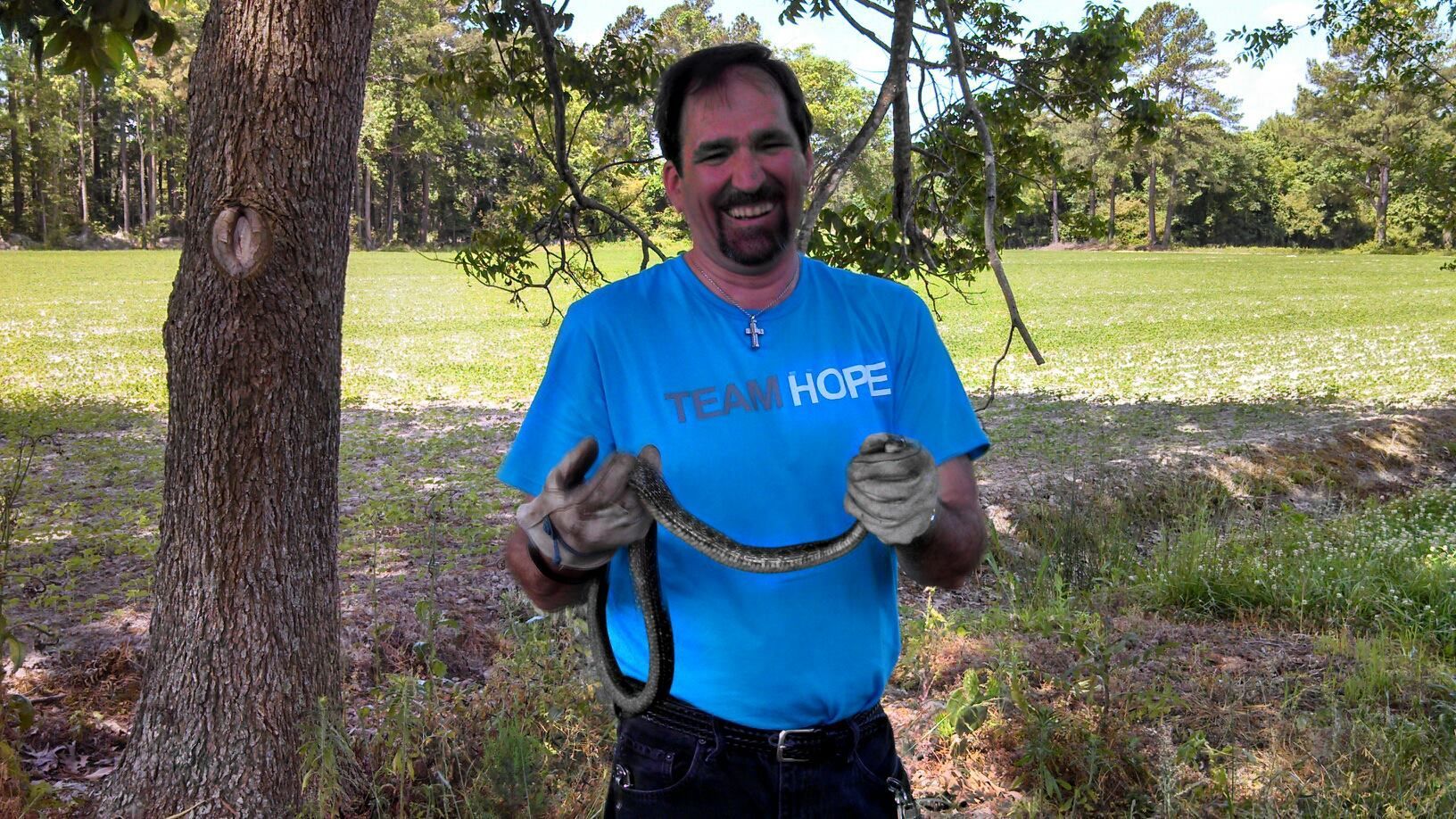 Man Holding A Cobra Snake — Greensboro, NC — The Critter Gitter LLC