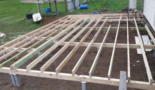 Wooden deck frame under construction outdoors.