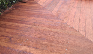 Wooden deck with chevron-patterned design, showing varying shades of reddish-brown.