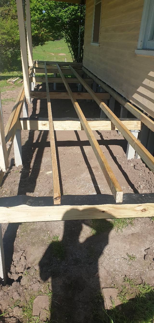 Wooden deck frame under construction near a house.