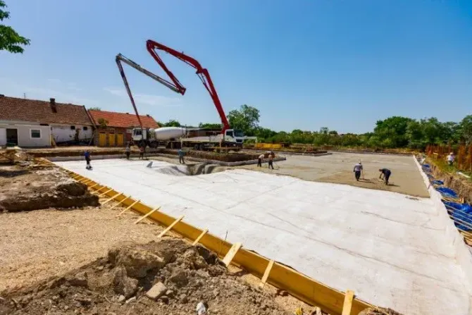 Concrete pump truck pouring foundation for a new house.