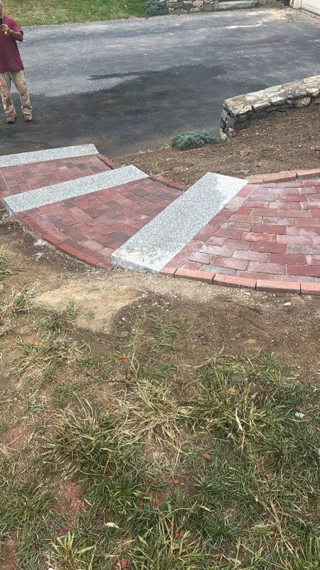 Brick steps with gray gravel inlays leading up to a driveway, person on the left.