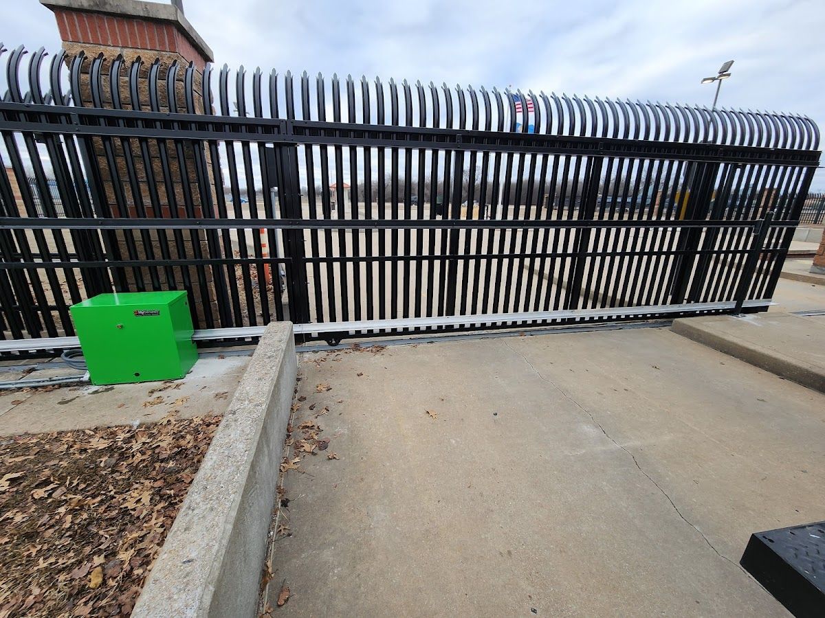 A black fence with a green box in front of it