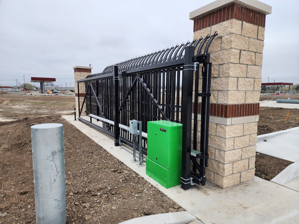 A green box is sitting next to a sliding gate.